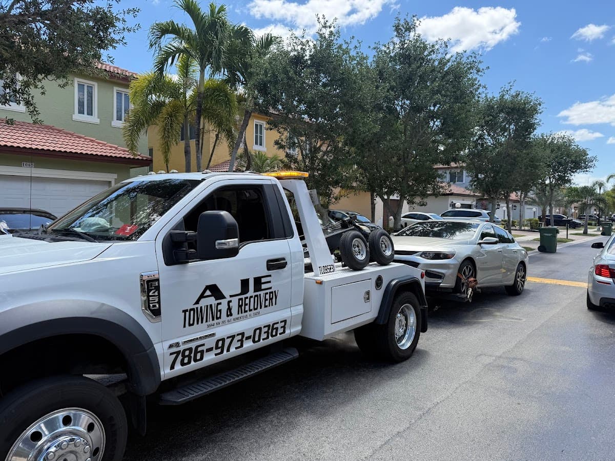 AJE Towing & Recovery flatbed wrecker in a Homestead, FL neighborhood