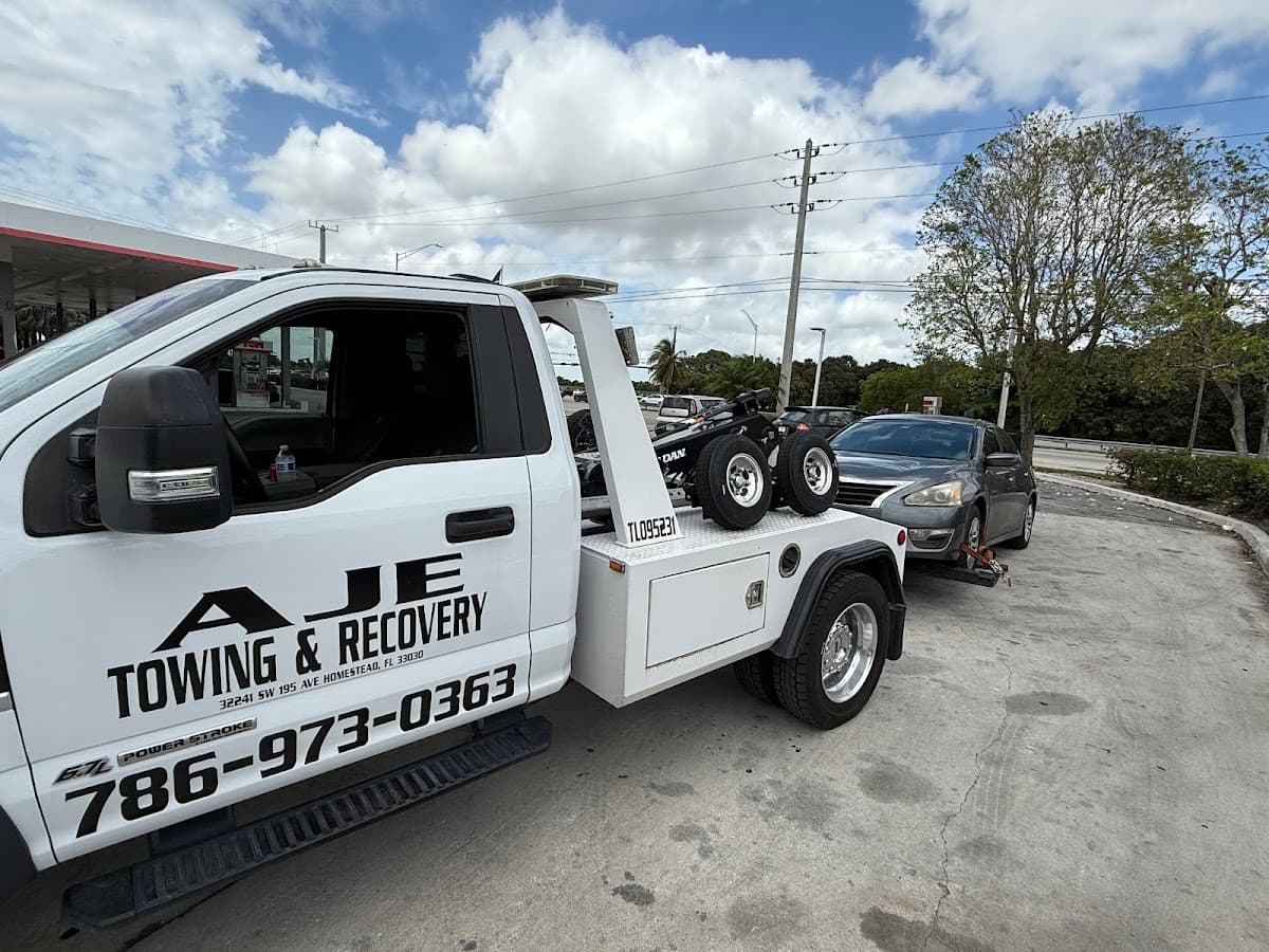 AJE Towing & Recovery wrecker flatbed with customer vehicle in Homestead, FL